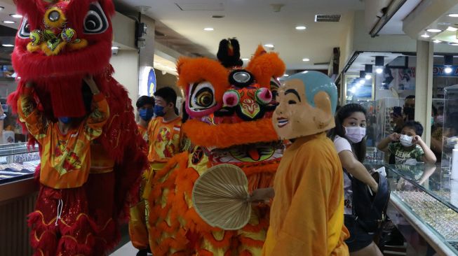 Barongsai beratraksi di salah satu pusat perbelanjaan di Surabaya, Jawa Timur, Sabtu (22/1/2022). [ANTARA FOTO/Didik Suhartono]