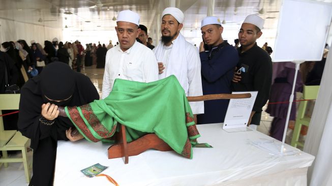 Pengunjung mencium salah satu barang peninggalan Nabi Muhammad SAW pada pameran artefak di kompleks Yayasan Zawiyah Nurun Nabi, Desa Lambhuk, Banda Aceh, Aceh, Sabtu (22/1/2022). [ANTARA FOTO/Syifa Yulinnas]