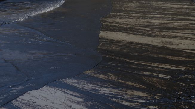 Tumpahan minyak terdampar di pantai di Provinsi Callao, Peru, pada (17/1/2022). [CRIS BOURONCLE / AFP]
