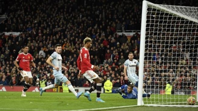 Pemain Manchester United Marcus Rashford menjebol gawang West Ham United dalam pertandingan Liga Premier Inggris di Old Trafford, Sabtu (22/1/2022). [AFP]