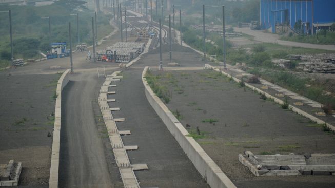 Pekerja memasang rel kereta di kawasan Stasiun Kereta Cepat Jakarta-Bandung di Tegalluar, Kabupaten Bandung, Jawa Barat, Minggu (23/1/2022). ANTARA FOTO/Raisan Al Farisi