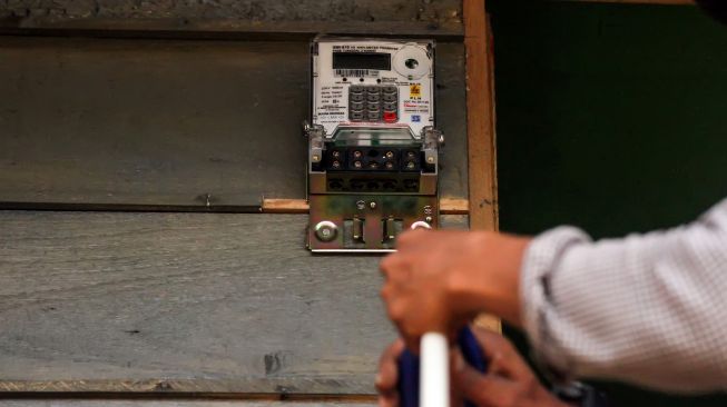Pekerja memasang meteran listrik di salah satu rumah warga saat pekerjaan pemasangan jaringan listrik program listrik masuk desa daerah tertinggal di Dusun Jabal Antara, Aceh Utara.