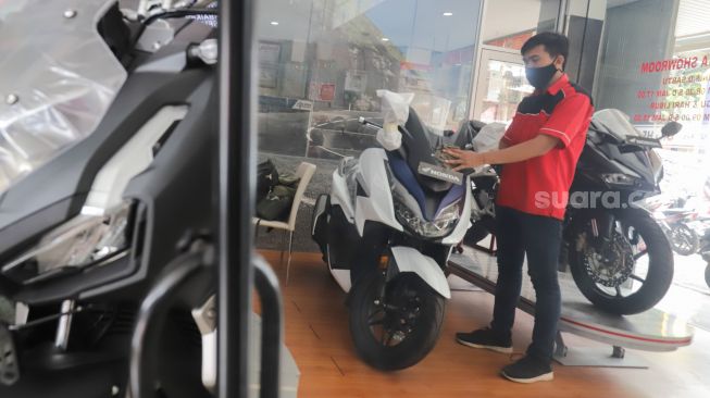 Petugas mengecek sepeda motor yang di panjang di salah satu dealer di kawasan Pasar Minggu, Jakarta Selatan, Minggu (23/1/2022). [Suara.com/Alfian Winanto]