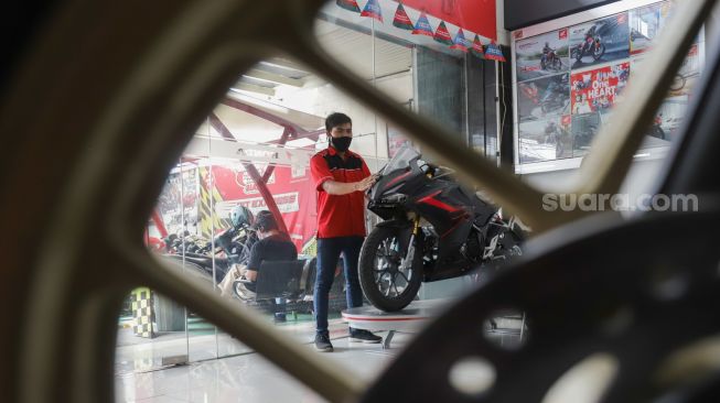 Petugas membersihkan sepeda motor yang di panjang di salah satu dealer di kawasan Pasar Minggu, Jakarta Selatan, Minggu (23/1/2022). [Suara.com/Alfian Winanto]