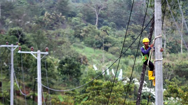 Pekerja memanjat tiang listrik saat pekerjaan pemasangan jaringan listrik program listrik masuk desa daerah tertinggal di Dusun Jabal Antara, Aceh Utara.