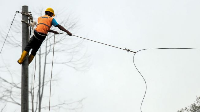 Pekerja memanjat tiang listrik saat pekerjaan pemasangan jaringan listrik program listrik masuk desa daerah tertinggal di Dusun Jabal Antara, Aceh Utara.