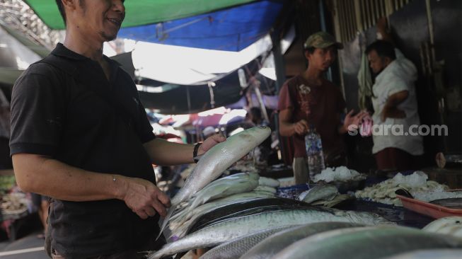 Pedagang menata ikan bandeng di kawasan Petak Sembilan, Glodok, Jakarta, Senin (24/1/2022). [Suara.com/Angga Budhiyanto]