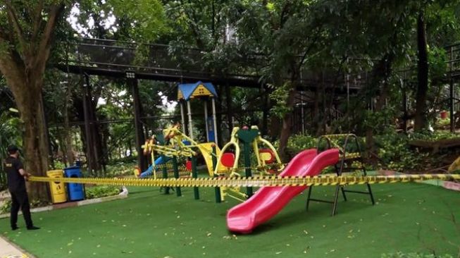 Petugas memasang garis polisi di Taman Gajah Tunggal seiring kebijakan penutupan taman tematik dan RTH oleh Pemkot Tangerang akibat melonjaknya kasus COVID-19, Jumat (21/1/2022). [Instagram@tamankita.tng]