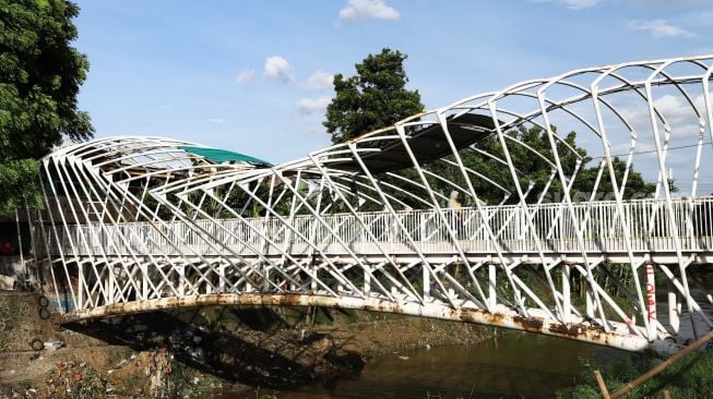 Warga melintas di Jembatan Penyeberangan Orang (JPO) Jayakarta di Menteng, Jakarta Pusat, Senin (24/1/2022). [Suara.com/Alfian Winanto]