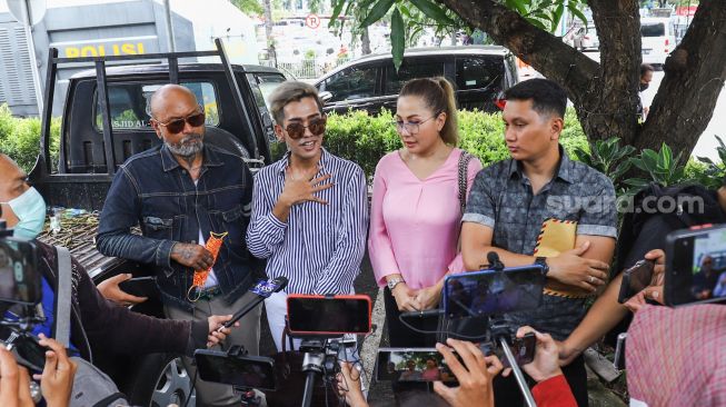 Artis Emma Waroka ditemani Kim Hawt menemui awak media saat datang untuk membuat laporan di Polda Metro Jaya, Jakarta Selatan, Senin (24/1/2022). [Suara.com/Alfian Winanto]