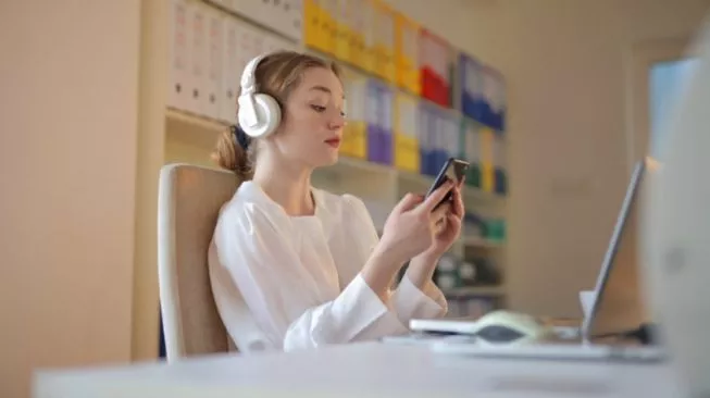 Mendengarkan streaming audio di aplikasi Spotify lewat smartphone menjadi bukti mengapa platform ini jadi pilihan utama distribusi podcast