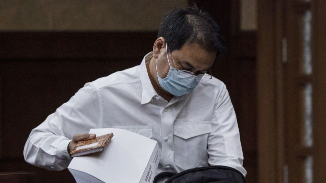 Terdakwa Azis Syamsuddin memasukkan berkas tuntutannya ke dalam tas seusai menjalani sidang tuntutan kasus suap kepada mantan penyidik KPK AKP Stepanus Robin Pattuju di Pengadilan Tipikor, Jakarta, Senin (24/1/2022).ANTARA FOTO/Sigid Kurniawan
