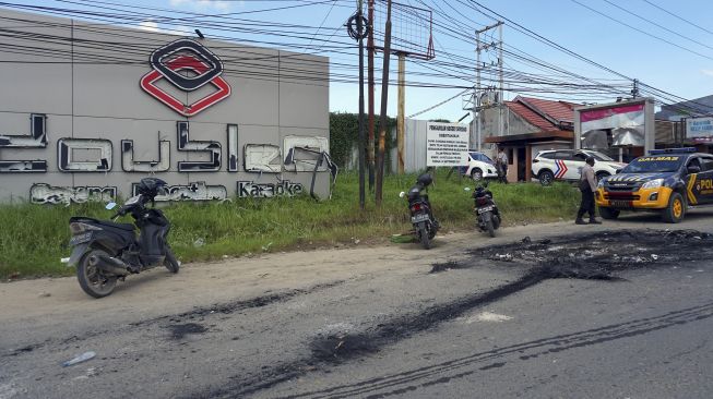 Sejumlah polisi berjaga di tempat hiburan malam Double O mengungsi usai bentrokan di Kota Sorong, Papua Barat, Selasa dini hari (25/1/2022). [ANTARA FOTO/Olha Mulalinda]