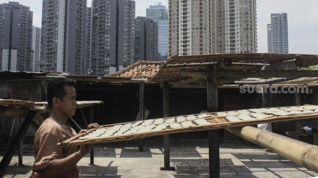 Pekerja menjemur kerupuk di UMKM Kerupuk Melati, Jakarta, Selasa (25/1/2022). [Suara.com/Septian]