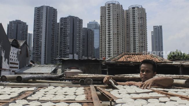 Pekerja menjemur kerupuk di UMKM Kerupuk Melati, Jakarta, Selasa (25/1/2022). [Suara.com/Septian]