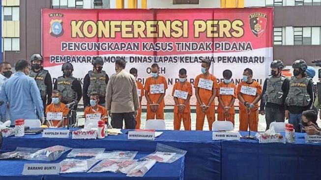 Polda Riau mengamankan 8 tersangka pembakaran mobil dinas Lapas Pekanbaru, tiga di antaranya merupakan pecatan anggota TNI-Polri. [Defri Candra/Riauonline]