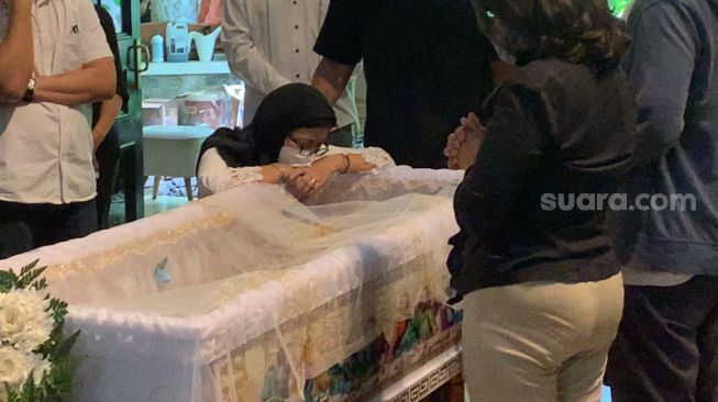 Nurul Arifin di samping peti jenazah putrinya, Maura Magnalia Madyaratri [Suara.com/Adiyoga Priyambodo]