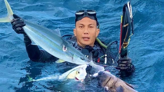 Anggota TNI Edy Effendi memperlihatkan hasil tangkapan dari aksi spearfishing yang dilakukannya. [Instagram]