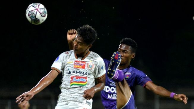 Pesepak bola Persija Jakarta Alfriyanto Nico Saputro (kiri) berebut bola dengan pesepak bola Persita Tangerang Altalariq Erfa Aqsal Ballah (kanan) saat pertandingan Liga 1 di Stadion I Gusti Ngurah Rai, Denpasar, Bali, Rabu (26/1/2022). Persija menang dengan skor 2-1. ANTARA FOTO/Fikri Yusuf/foc.