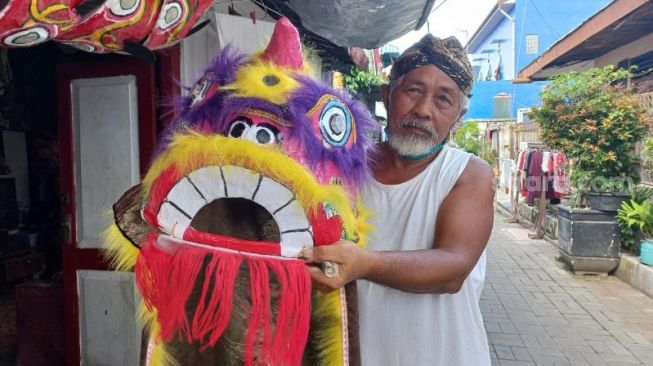 Pak Pong memegang barongsai ukuran kecil yang sudah siap dijual - (SuaraJogja.id/Rahmat Jiwandono)