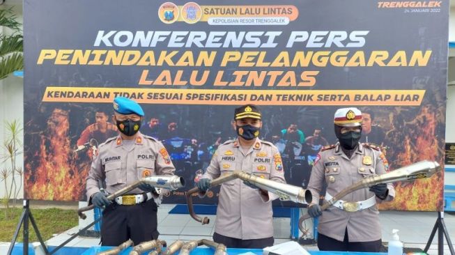 Petugas menunjukkan knalpot yang tidak sesuai spektek saat konferensi pers hasil razia balap liar (ANTARA/HO-Humas Polres Trenggalek) 