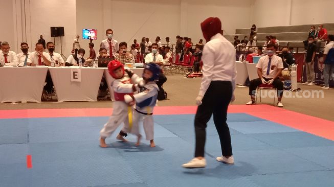 Jan Ethes Srinarendra (merah) saat bertanding di Kejuaraan Taekwondo Piala Wali Kota Solo Convention Hall Terminal Tirtonadi Solo, Jumat (28/1/2022). (Suara.com/Ari Welianto]