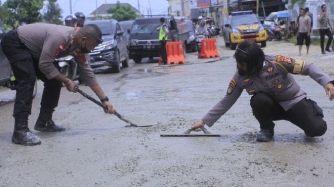 Aksi Polwan Tambal Jalan Berlubang di Kupang Jadi Tontonan Warga