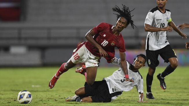 Pemain Timnas Indonesia Ronaldo (kiri) dihadang oleh pemain Timnas Timor Leste Orcelio Nobelito dalam pertandingan sepak bola Leg 1 FIFA Matchday di Stadion I Wayan Dipta, Gianyar, Bali, Kamis (27/1/2022). [ANTARA FOTO/Nyoman Budhiana]