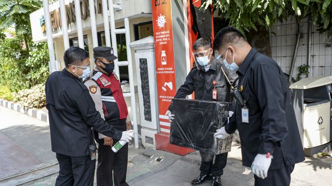 Petugas keamanan menyemprotkan cairan disinfektan pada paket barang di Kantor Pusat Kementerian Sosial (Kemensos), Jakarta, Jumat (28/1/2022). [ANTARA FOTO/M Risyal Hidayat]