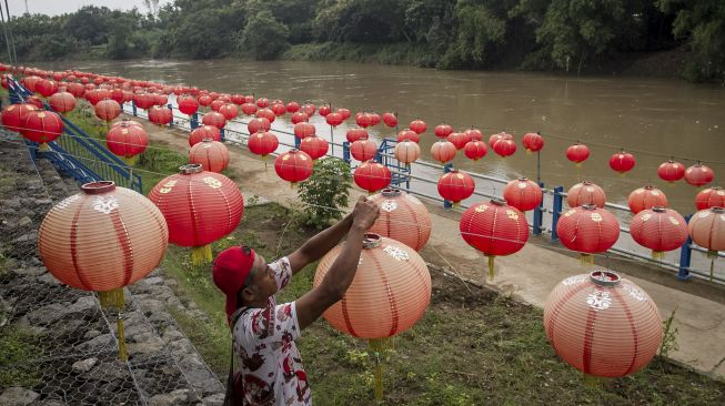 Warga memasang hiasan lampion menyambut Tahun Baru Imlek 2022 di Taman Sunan Jogo Kali pinggir Sungai Bengawan Solo, Pucang Sawit, Solo, Jawa Tengah, Kamis (27/1/2022). [ANTARA FOTO/Mohammad Ayudha]