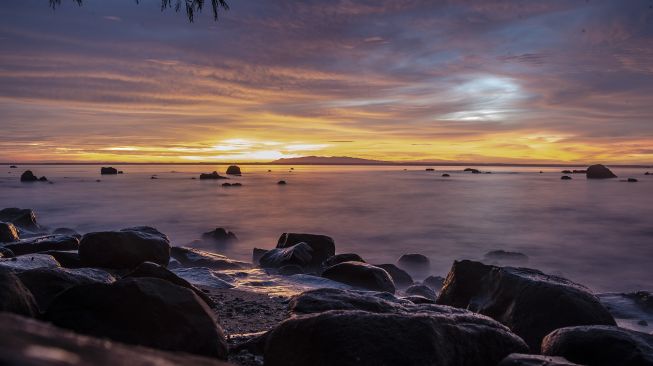 Suasana senja di Pantai Taman Jaya, Pandeglang, Banten, Jumat (28/1/2022). [ANTARA FOTO/Muhammad Adimaja]