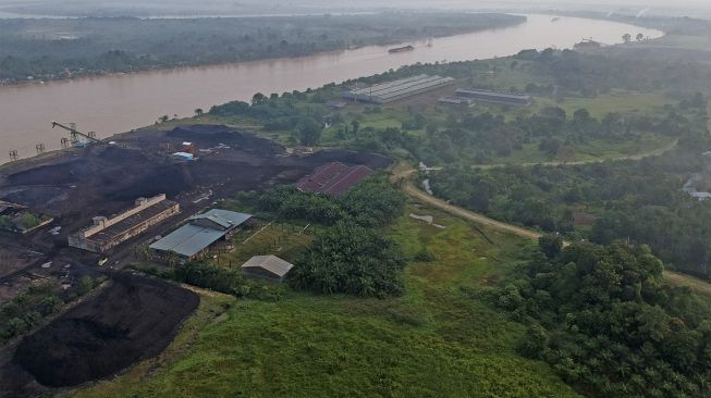 Foto udara suasana aktivitas industri penumpukan batu bara di Kawasan Cagar Budaya Nasional (KCBN) Muarajambi, Taman Rajo, Muarojambi, Jambi, Sabtu (29/1/2022). [ANTARA FOTO/Wahdi Septiawan]