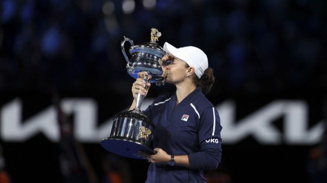 Petenis Australia, Ashleigh Barty mencium trofi setelah menang melawan Danielle Collins dari AS dalam pertandingan final tunggal putri pada hari ketiga belas turnamen tenis Australian Open 2022 di Melbourne pada 29 Januari 2022.Martin KEEP / AFP.