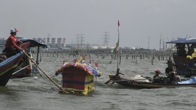 Sejumlah nelayan dan warga melarung (menghanyutkan) sesaji di laut Tarumajaya, Kabupaten Bekasi, Jawa Barat, Jumat (28/1/2022). [ANTARA FOTO/Fakhri Hermansyah]