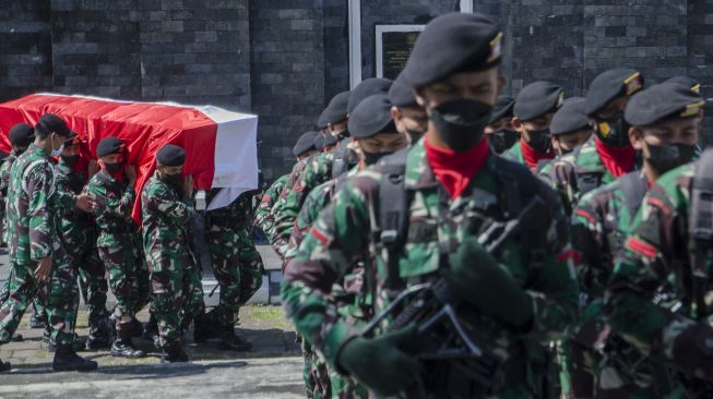 Prajurit TNI menggotong jenazah Prajurit TNI AD Sertu Anumerta Mochamad Rizal Maulana Arifin saat upacara militer pemakaman di Taman Makam Pahlawan Cikutra, Bandung, Jawa Barat, Sabtu (19/1/2022). [ANTARA FOTO/Novrian Arbi]