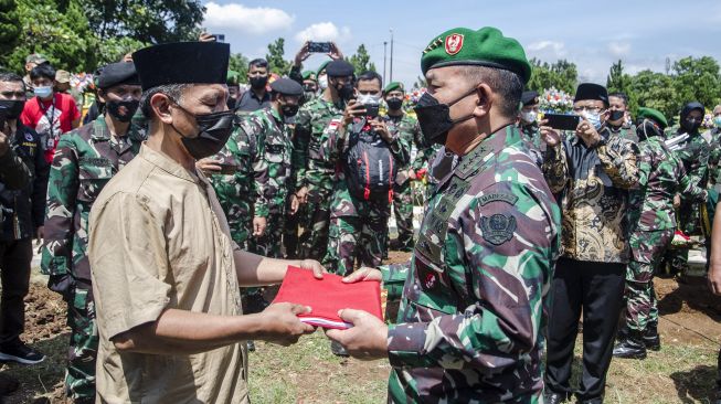 Kepala Staf Angkatan Darat Jenderal TNI Dudung Abdurachman (kanan) menyerahkan bendera Merah Putih kepada pihak keluarga usai mempimpin upacara militer pemakaman Prajurit TNI AD Sertu Anumerta Mochamad Rizal Maulana Arifin di Taman Makam Pahlawan Cikutra, Bandung, Jawa Barat, Sabtu (19/1/2022). [ANTARA FOTO/Novrian Arbi]