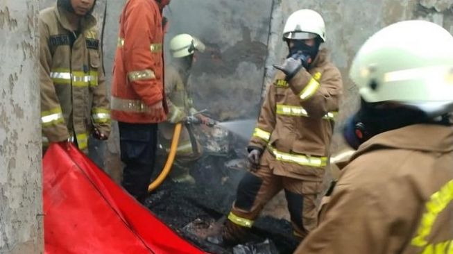 Petugas Suku Dinas Gulkarmat Jakarta Selatan mengevakuasi korban kebakaran yang tewas di Kelurahan Kebon Baru, Tebet, Jakarta Selatan, Sabtu (29/1/2022). [Dok. Sudin Gulkarmat Jakarta Selatan]