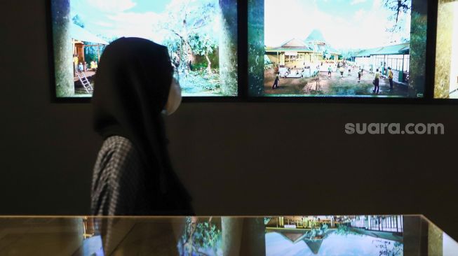 Pengunjung melihat karya seni yang ditampilkan dalam pameran 'Para Sekutu yang Tidak Bisa Berkata Tidak' di Galeri Nasional Indonesia, Jakarta Pusat, Minggu (30/1/2022). [Suara.com/Alfian Winanto]