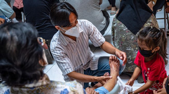 Warga keturunan Tionghoa membasuh kaki orang tua mereka saat mengikuti tradisi Bakti Basuh Kaki Orang Tua di Gedung Rasa Dharma Kawasan Pecinan Semarang, Jawa Tengah, Minggu (30/1/2022).  ANTARA FOTO/Aji Styawan
