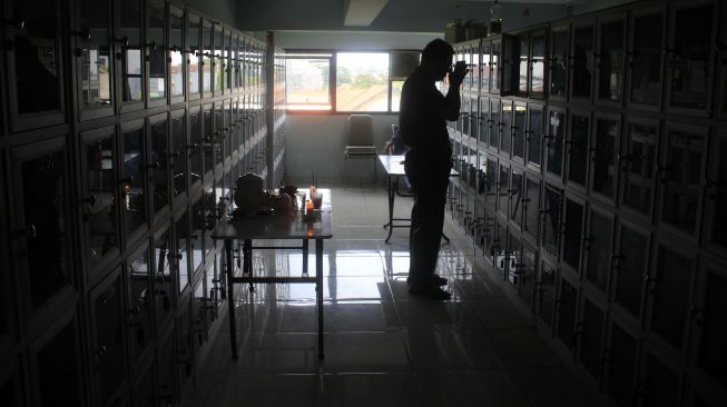 Warga keturunan Tionghoa melakukan tradisi sembahyang leluhur di ruang penitipan abu jenazah Yayasan Adi Jasa, Surabaya, Jawa Timur, Sabtu (29/1/2022).  ANTARA FOTO/Patrik Cahyo Lumintu