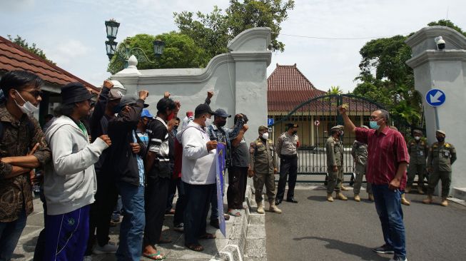 Warga yang tergabung dalam paguyuban pendorong gerobak PKL Malioboro melakukan aksi damai di depan Kantor Gubernur DIY, Yogyakarta, Senin (31/1/2022). ANTARA FOTO/Andreas Fitri Atmoko