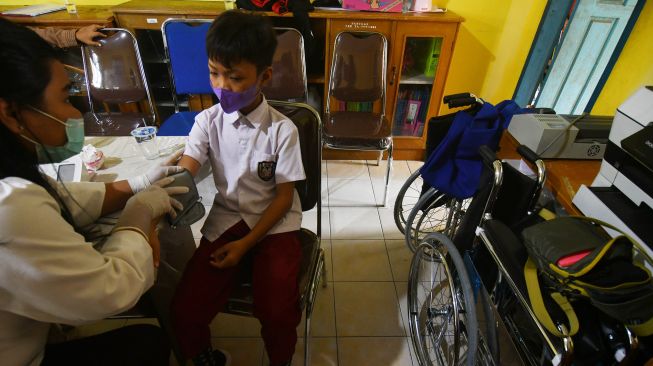 Petugas medis memeriksa kondisi kesehatan siswa berkebutuhan khusus sebelum mengikuti vaksinasi COVID-19 di SLB ABCD Muhammadiyah di Palu, Sulawesi Tengah, Senin (31/1/2022).  ANTARA FOTO/Mohamad Hamzah