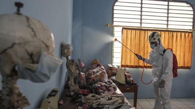 Petugas Palang Merah Indonesia (PMI) menyemprotkan disinfektan di salah satu sekolah di Depok, Jawa Barat, Senin (31/1/2022).  ANTARA FOTO/Asprilla Dwi Adha