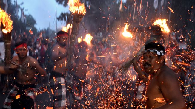 Sejumlah warga saling memukulkan api dari daun kelapa kering saat mengikuti tradisi "Siat Api" atau perang api di Desa Adat Duda, Karangasem, Bali, Senin (31/1/2022).  ANTARA FOTO/Fikri Yusuf