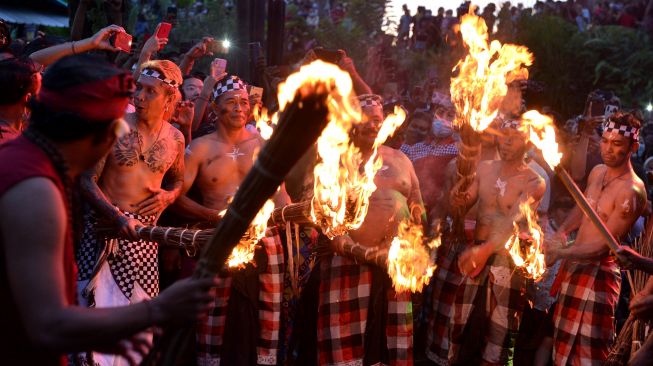 Sejumlah warga bersiap memukulkan api dari daun kelapa kering saat mengikuti tradisi "Siat Api" atau perang api di Desa Adat Duda, Karangasem, Bali, Senin (31/1/2022). ANTARA FOTO/Fikri Yusuf
