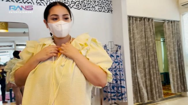 Nagita Slavina mencoba baju yang akan dibelinya. [RANS Entertainment]