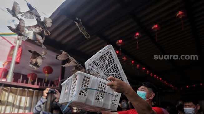 Warga keturunan Tionghoa melepaskan burung pipit saat bersembahyang di Vihara Dharma Bhakti, Jakarta, Selasa (1/2/2022). [Suara.com/Angga Budhiyanto]