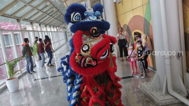 Barongsai beratraksi di Stasiun LRT Boulevard Utara, Kelapa Gading, Jakarta, Selasa (1/2/2022). [Suara.com/Angga Budhiyanto]