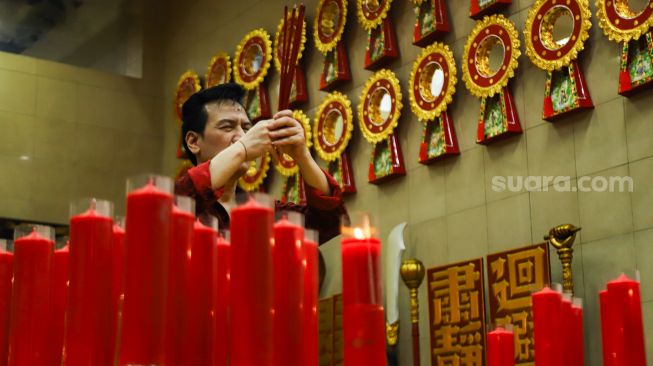 Warga Tionghoa melakukan ibadah malam imlek di Vihara Amurva Bhumi, Jakarta Timur, Senin (31/1/2022). [Suara.com/Alfian Winanto]