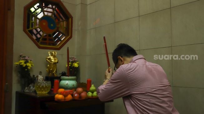 Warga Tionghoa melakukan ibadah malam imlek di Vihara Amurva Bhumi, Jakarta Timur, Senin (31/1/2022). [Suara.com/Alfian Winanto]